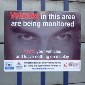 vehicles are being monitored in this area sign with eyes in the background mounted onto a gate