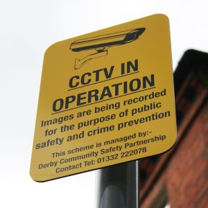 Yellow cctv in operation sign mounted to lamppost