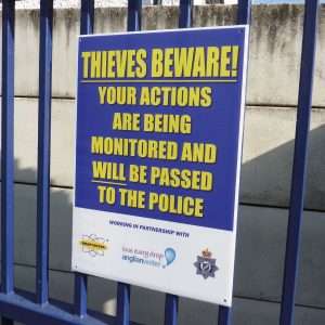thieves beware sign mounted to gate