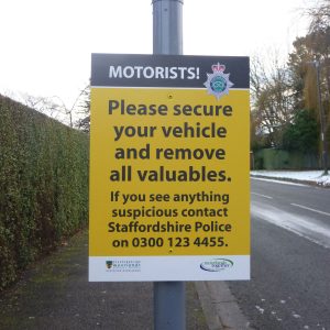 lamppost mounted sign advising motorists to secure your vehicle & remove all valuables