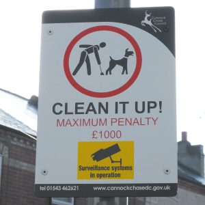 lamppost mounted sign advising dog owners to clean up after their dogs or face a fine