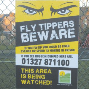 bold yellow sign advising the public that fly tipping is not acceptable