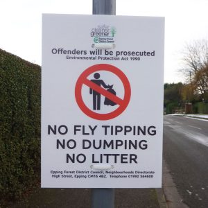 white lamppost mounted sign advising the public that no fly tipping is acceptable