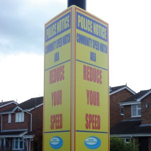 tri-ad sign attached to lamppost advising road users to reduce their speed