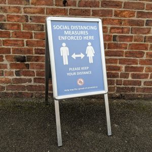 collapsable sign informing public of social distancing measures in place